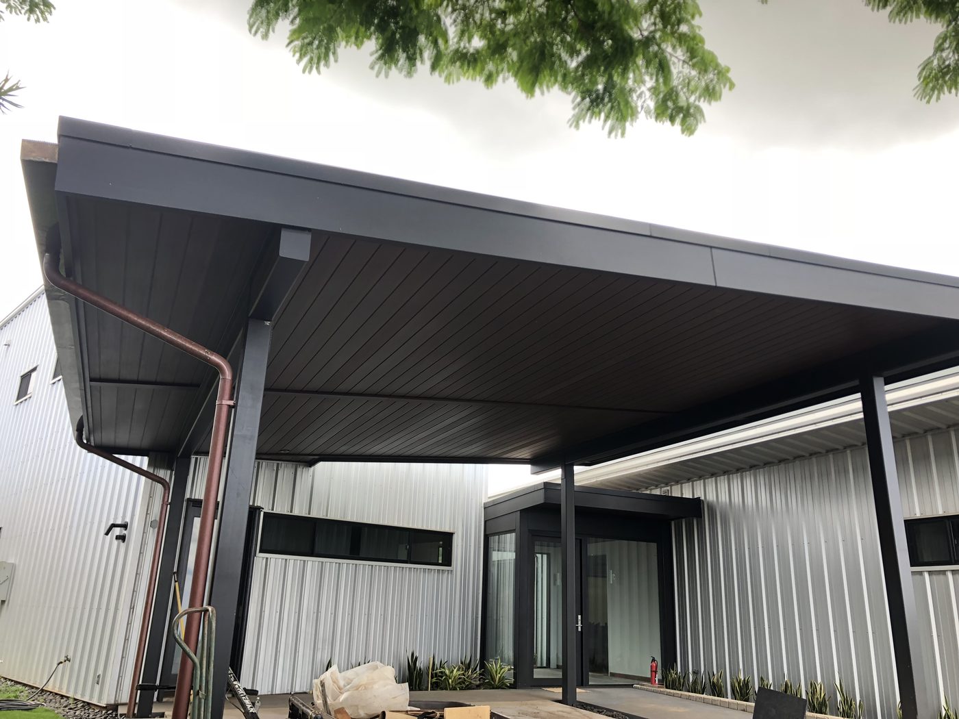 Covered entry with dark metal fascia and standing seam roofline