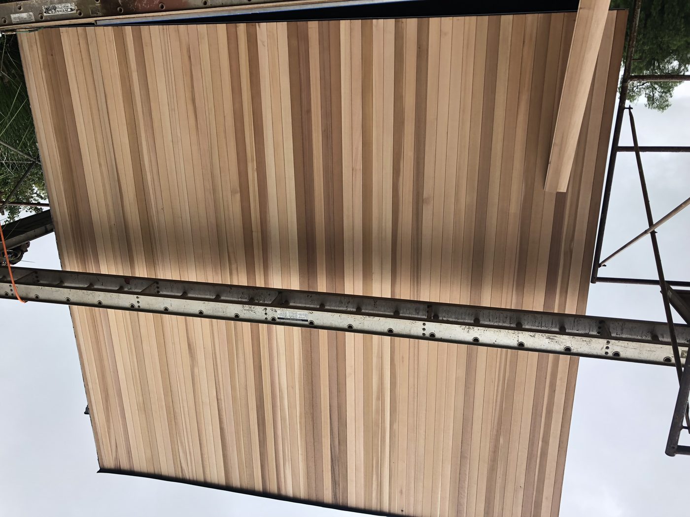 Vertical cedar siding installed from scaffold