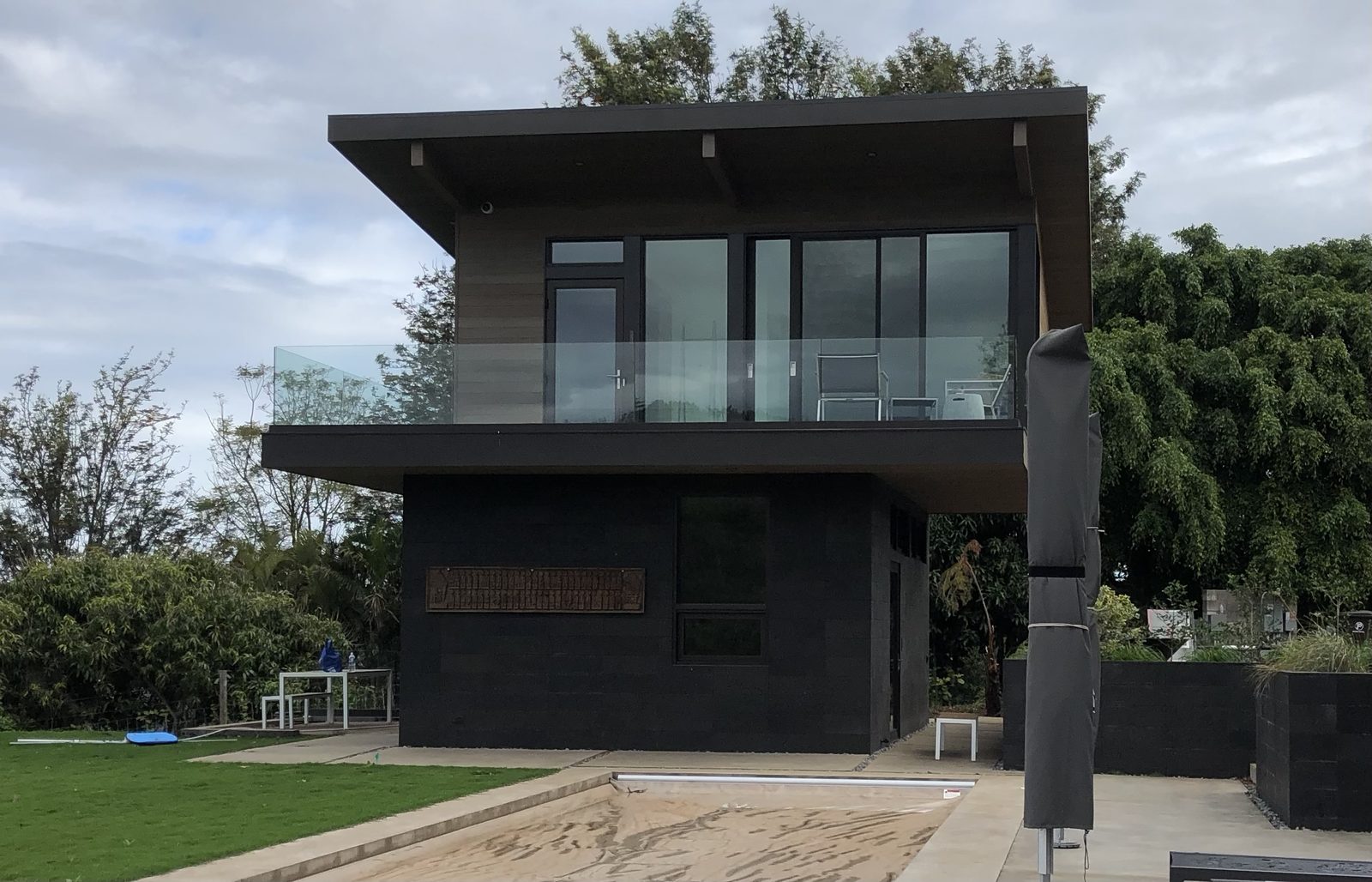 Finished two-story home with deep eaves and a glass railing, Maui