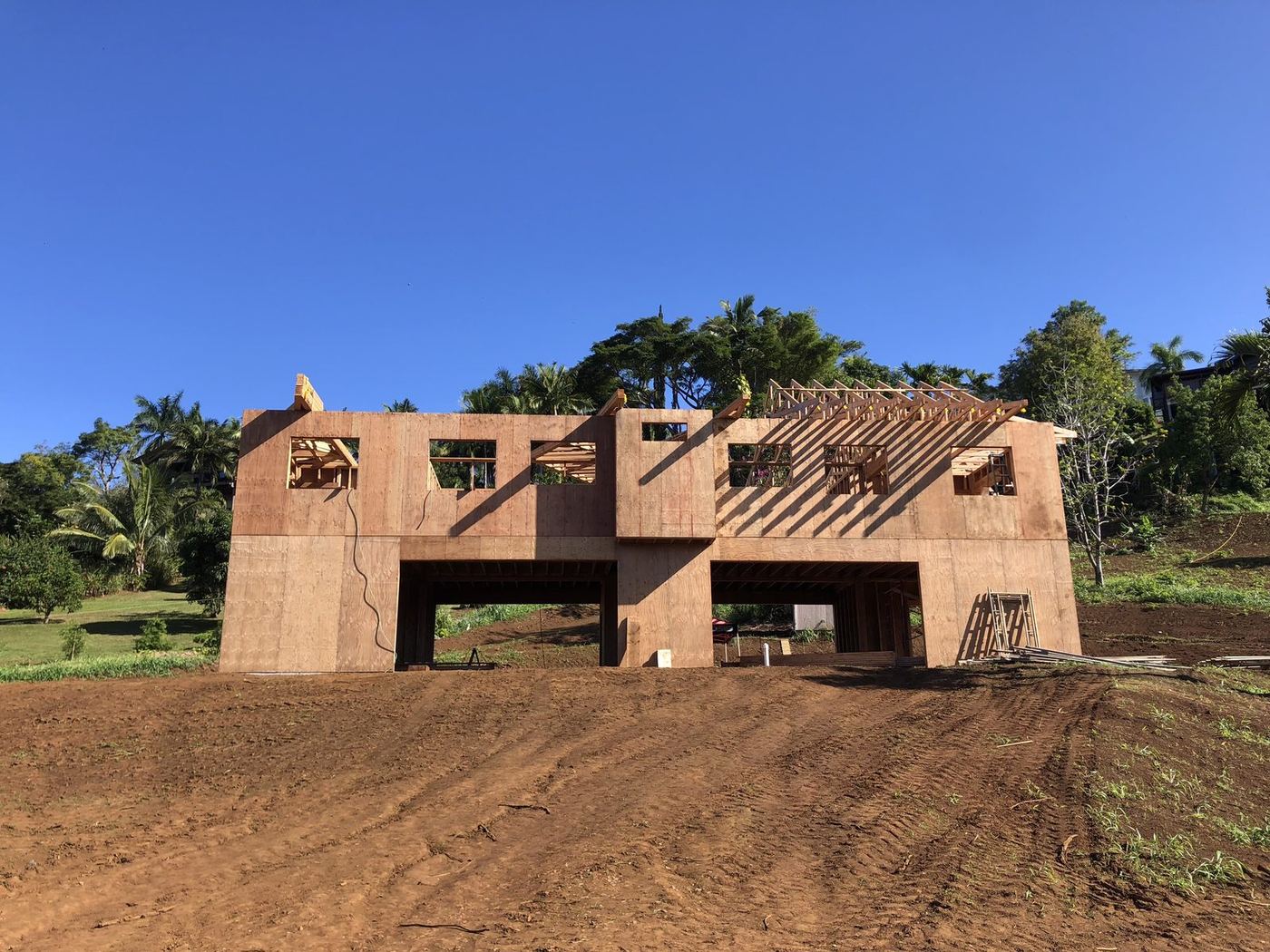 Two-story framing and roof trusses on a Maui hillside build